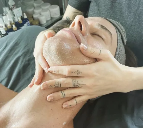 Person receiving a facial massage with oils